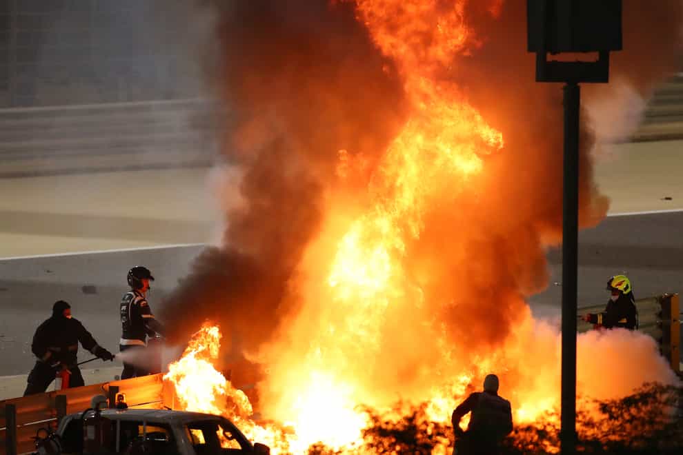 Staff extinguish flames from Romain Grosjean's Haas