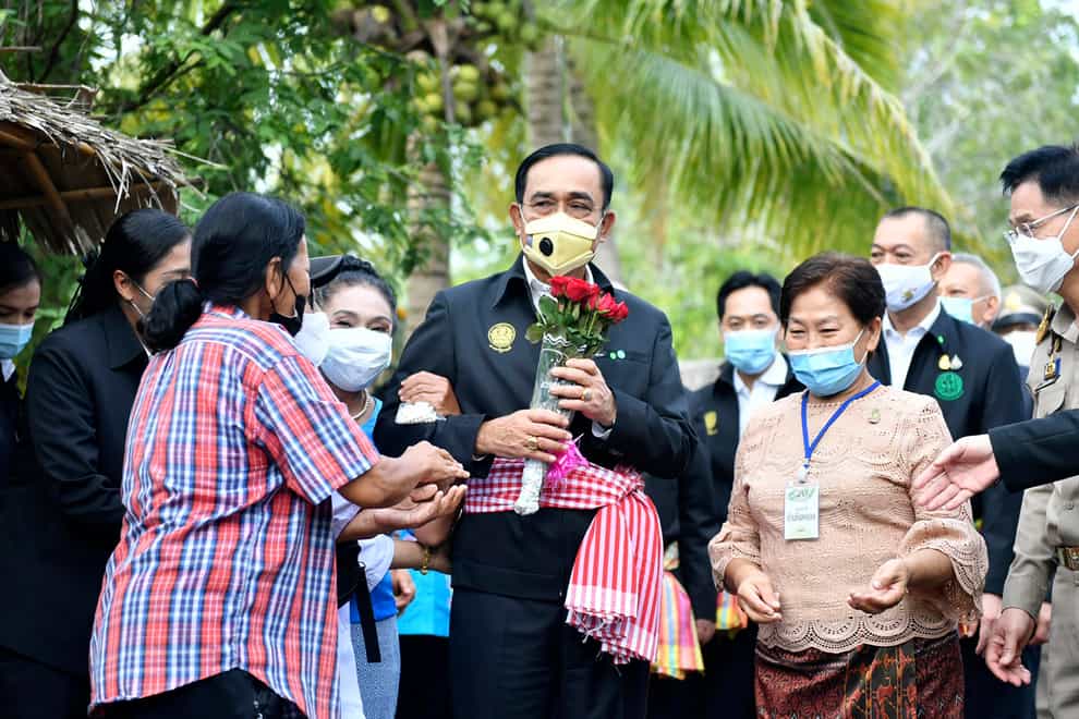 Thailand’s prime minister Prayuth Chan-ocha receives flowers from well wishers in Samut Songkhram province, Thailand (Spokesman's Office/AP)
