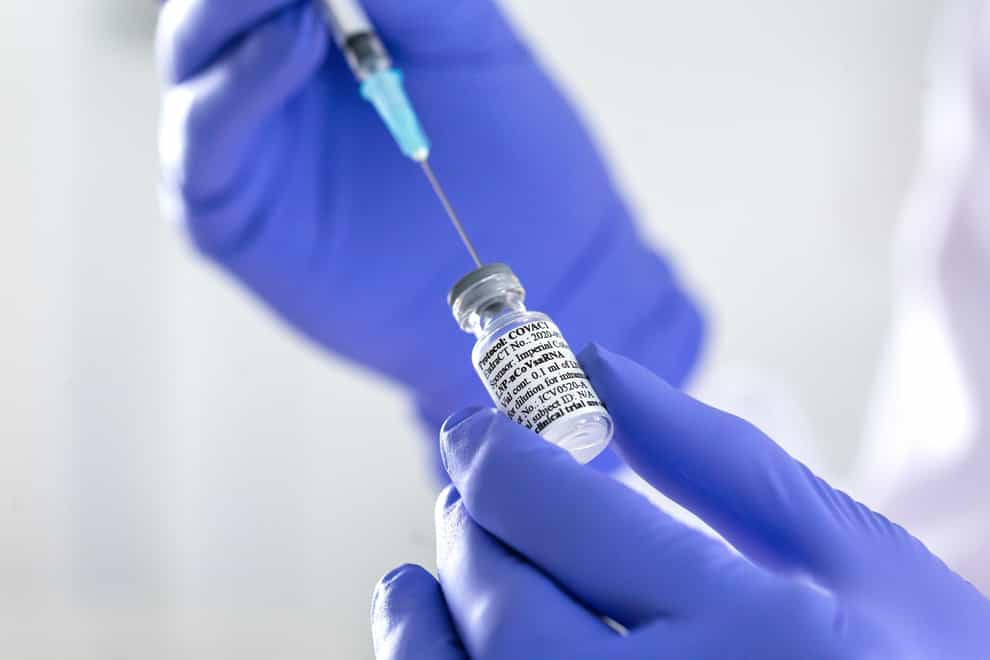A person wearing medical gloves and holding a potential Covid-19 vaccine