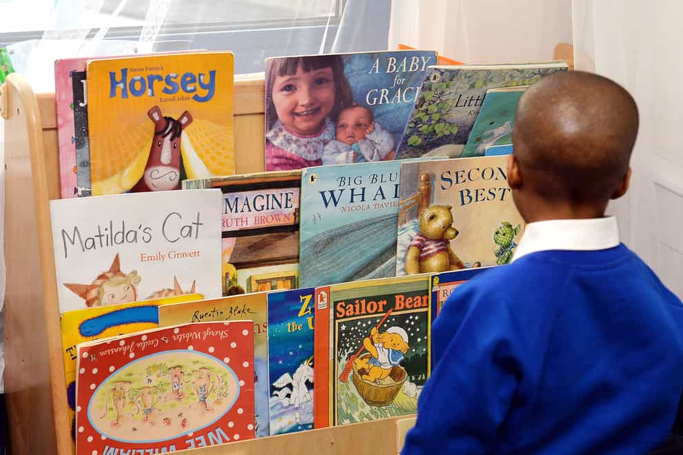 A child looking at books in a nursery
