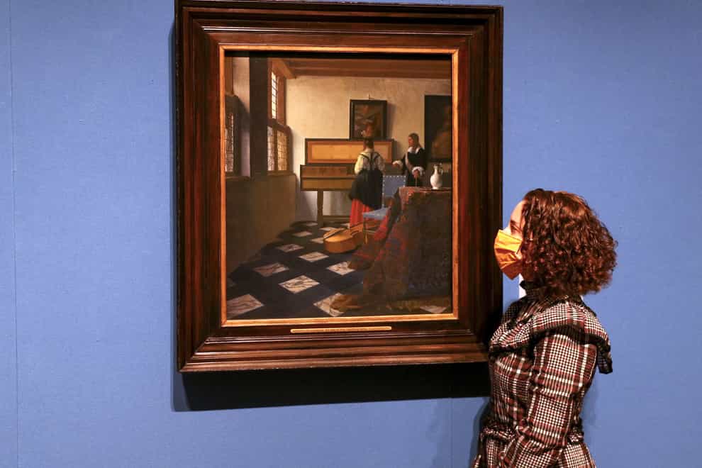 Woman looks at Vermeer painting