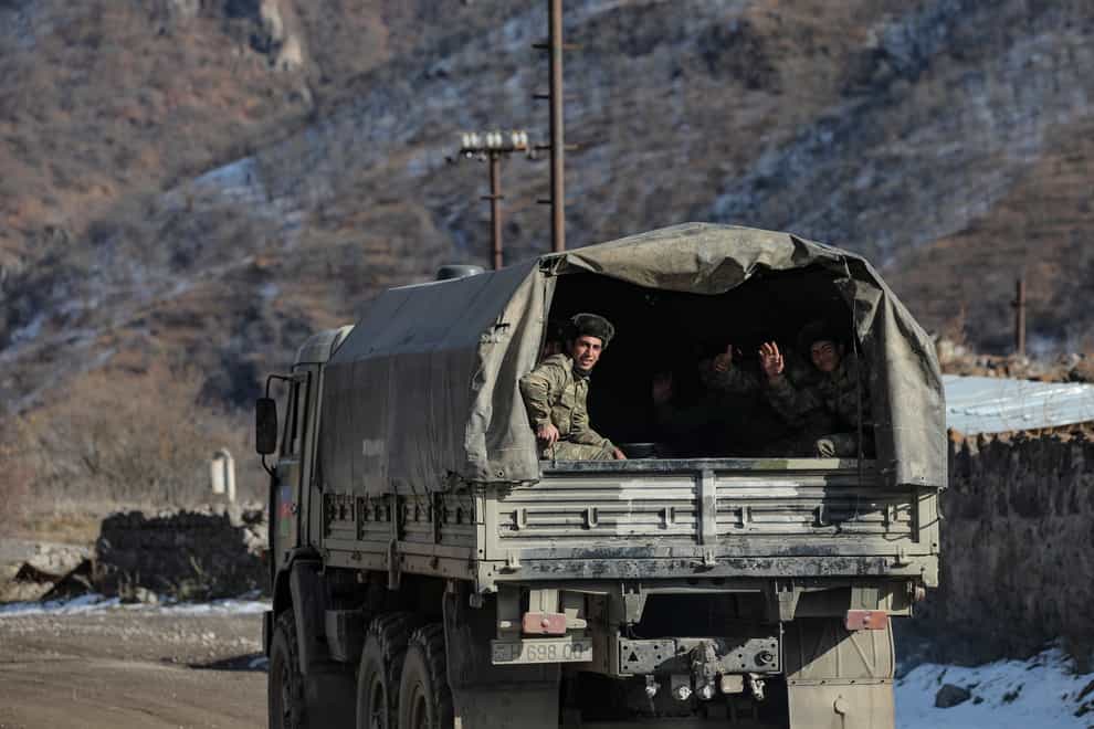 Azerbaijani soldiers sit in a military lorry on a road to their military tent camp after the transfer of the Kalbajar region to Azerbaijan’s control (Emrah Gurel/AP)