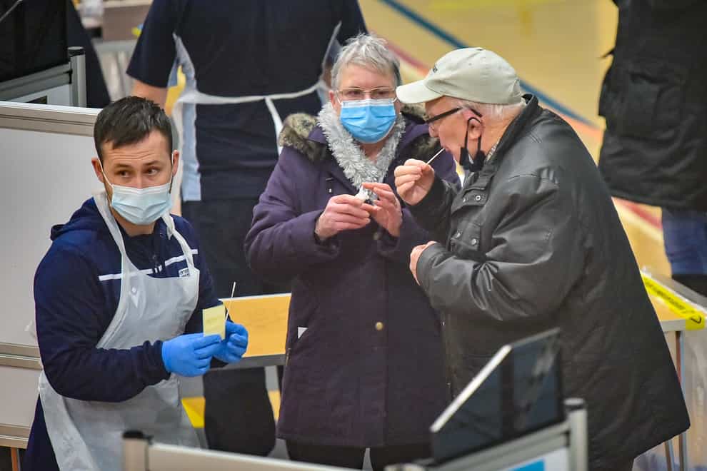 Members of the public complete a Covid-19 test at Rhydycar leisure centre in Merthyr Tydfil (Ben Birchall/PA)