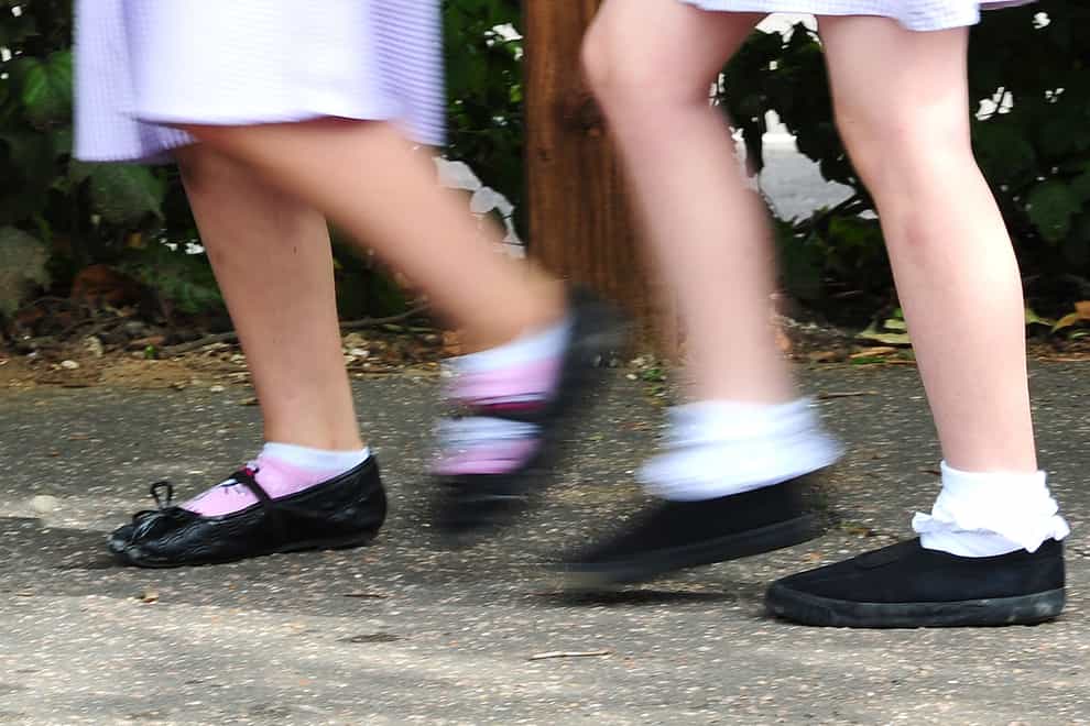 School girls walking to school (Ian West/PA)