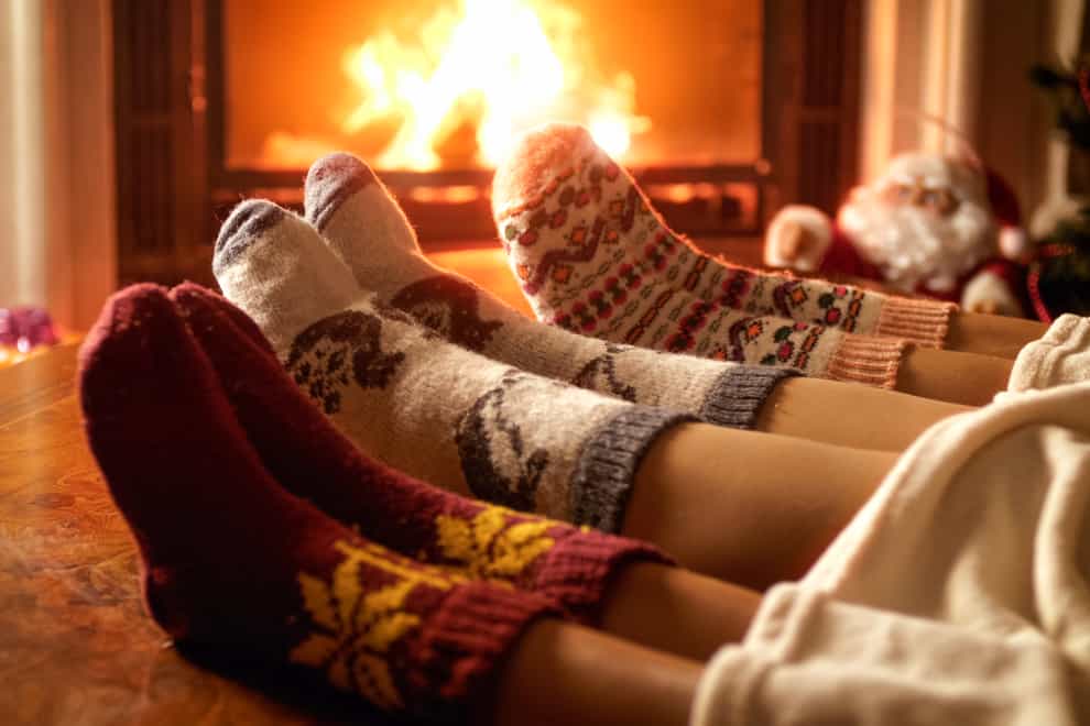Closeup photo of family feet in woolen socks lying next to fireplace