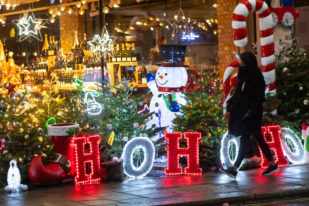 A shopper passes a Christmas light display outside a store in Mayfair, central London