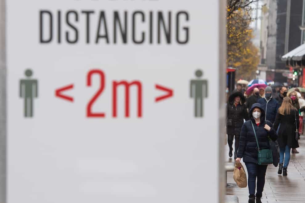 Shoppers pass social distancing signs on Oxford Street in central London