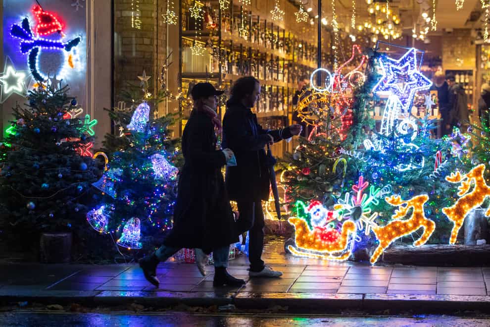 Shoppers pass a Christmas light display outside a store in Mayfair, central London