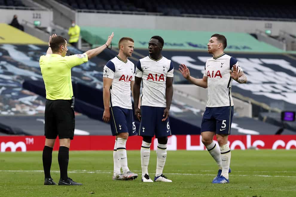Tottenham Hotspur players surround referee Peter Bankes after he awards a penalty against Tottenham’s Eric Dier for handball