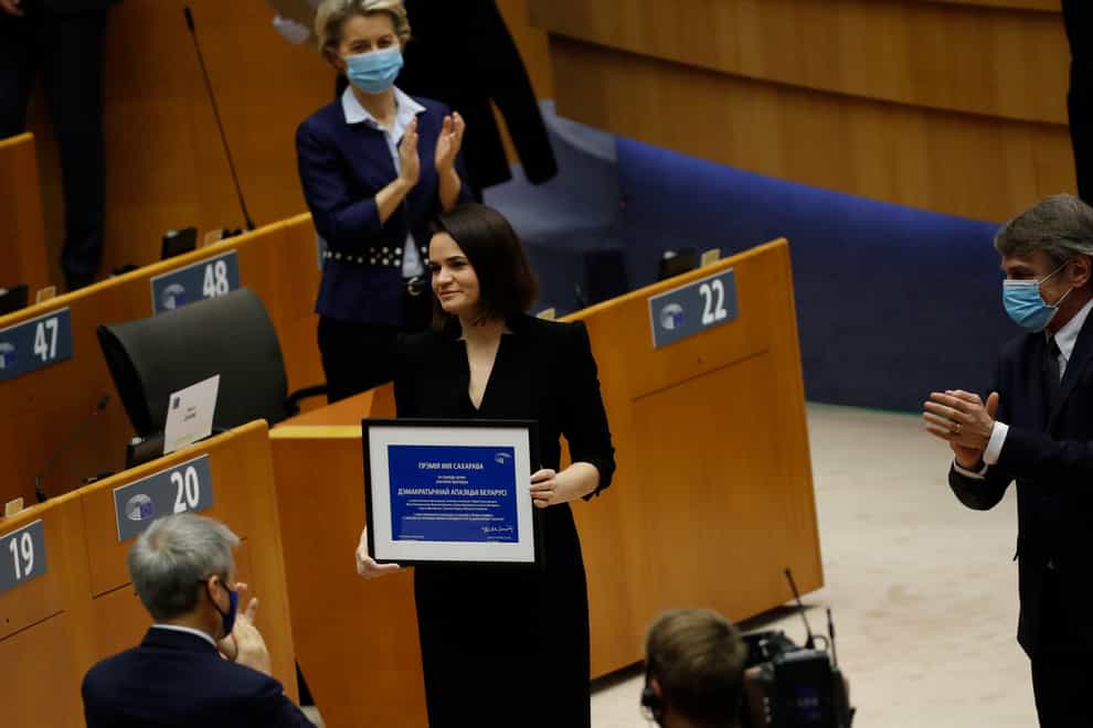 Belarusian opposition politician Sviatlana Tsikhanouskaya (centre) is applauded as holds her prize