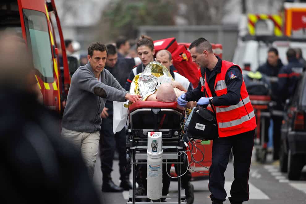 An injured person is taken to an ambulance after the shooting at Charlie Hebdo
