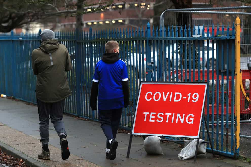People walk past a Covid-19 testing sign