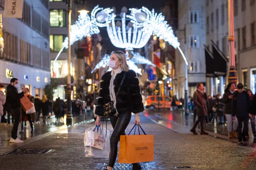 Shoppers pass Christmas light displays in London's New Bond Street