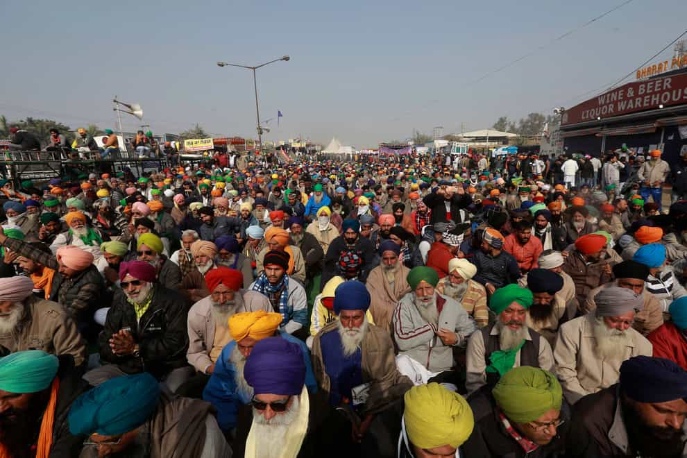 Protesting farmers listen to a speaker at the Delhi- Haryana border