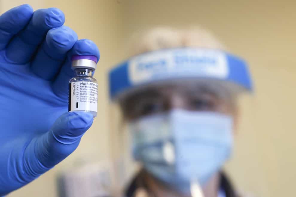 An NHS worker holds a dose of the Pfizer vaccine at the Gloucestershire Royal Hospital