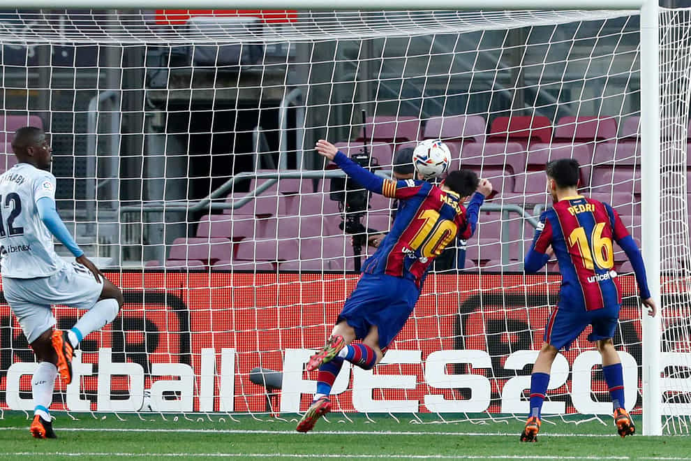 Barcelona’s Lionel Messi (centre) heads the ball to score a goal