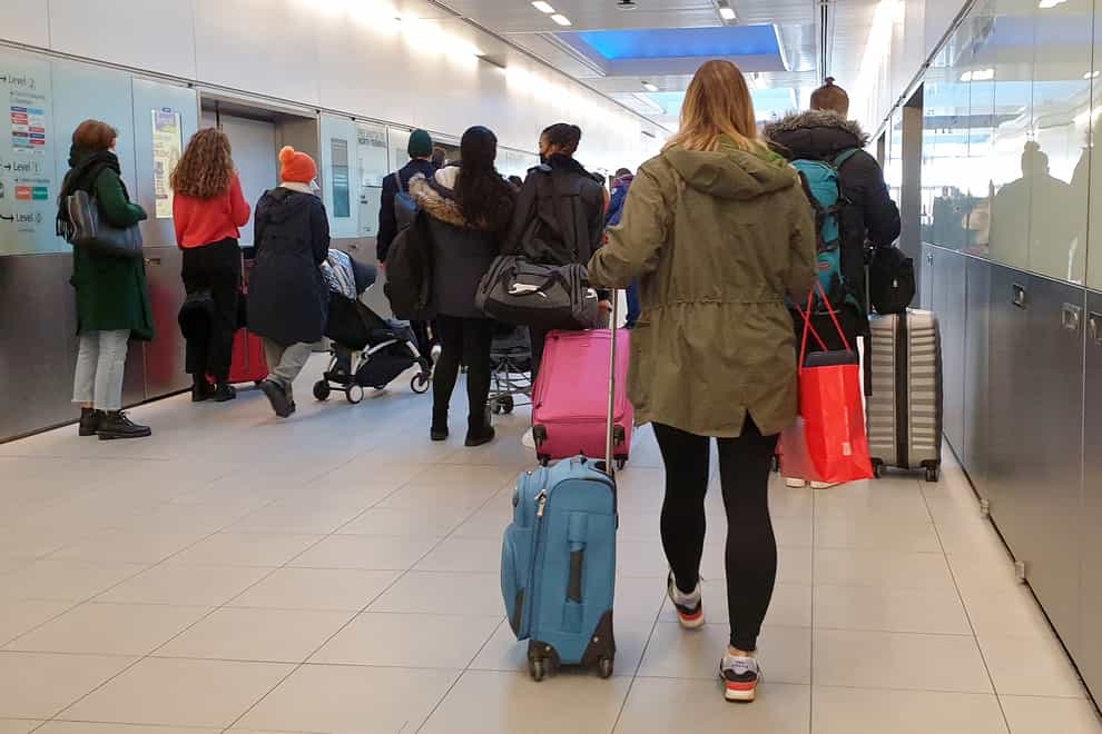 People queue for a shuttle train at Gatwick Airport in West Sussex, amid concerns that borders will close