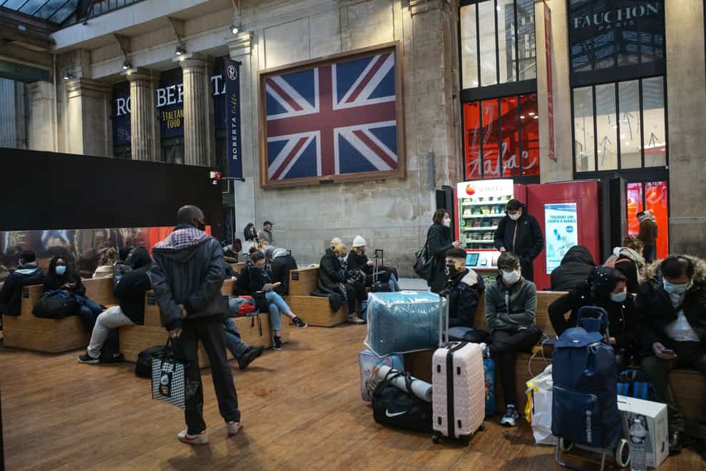 Passengers wearing face masks wait next to the Eurostar Terminal at Gare du Nord train station in Paris