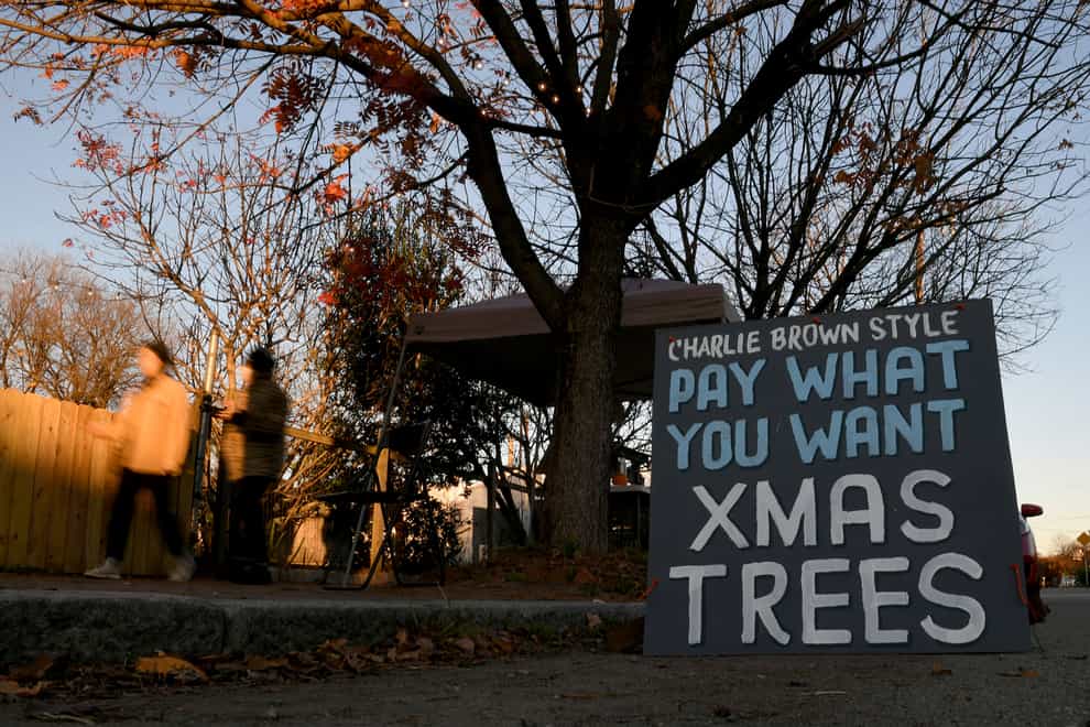 Pedestrians walk past Frank Pichel’s tree lot in Richmond, Virginia