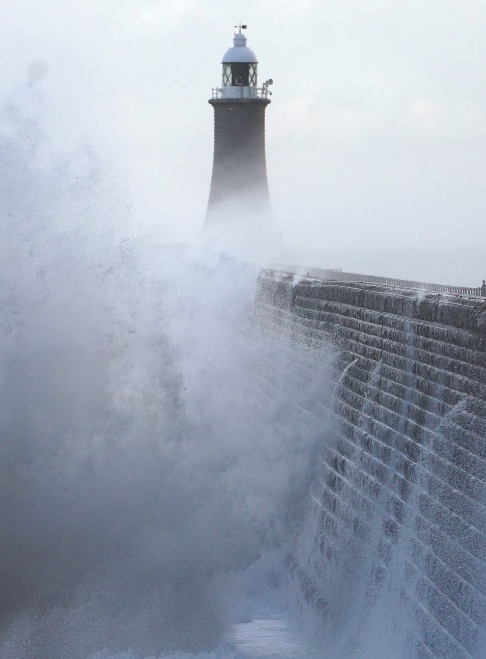 Waves crash against the pier wall at Tynemouth