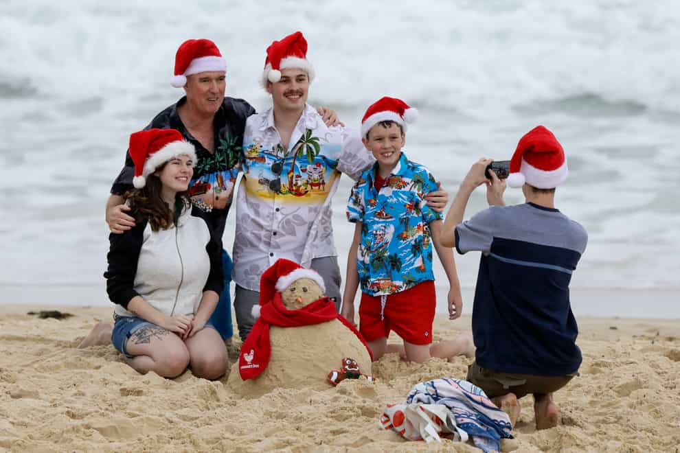 <p>A family pose for a photo on Christmas Day at Sydney’s Bondi Beach&nbsp;</p>