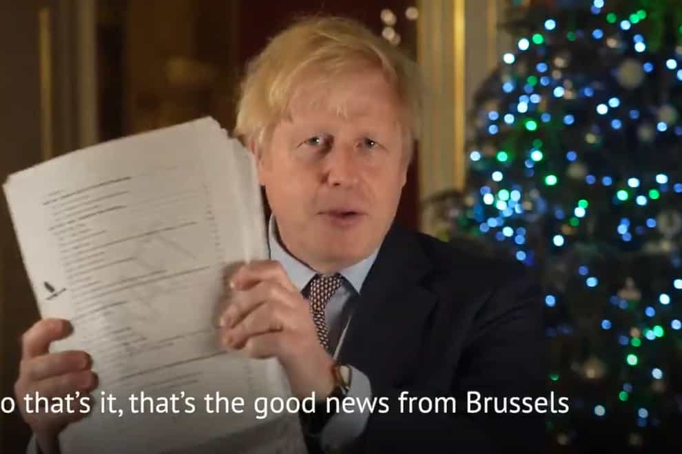 Prime Minister Boris Johnson holding up the Brexit deal during his Christmas message recorded in 10 Downing Street (@borisjohnson/PA)