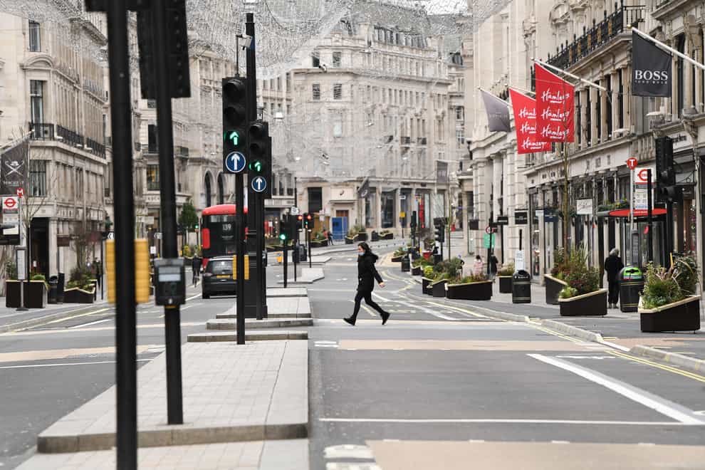 Woman walks across empty Regent Street in London on Boxing Day