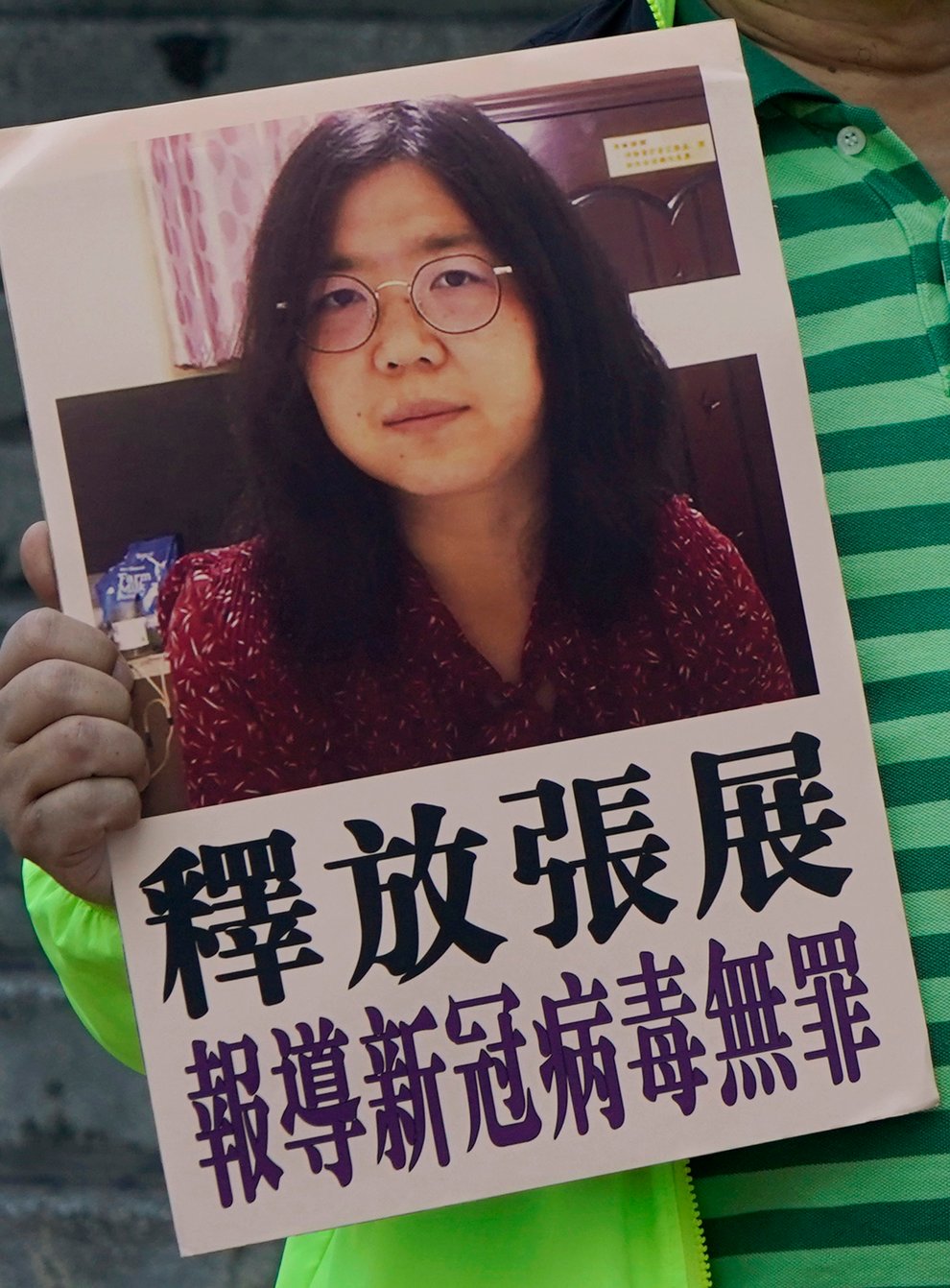 A pro-democracy activist holds placards with the picture of Chinese citizen journalist Zhang Zhan