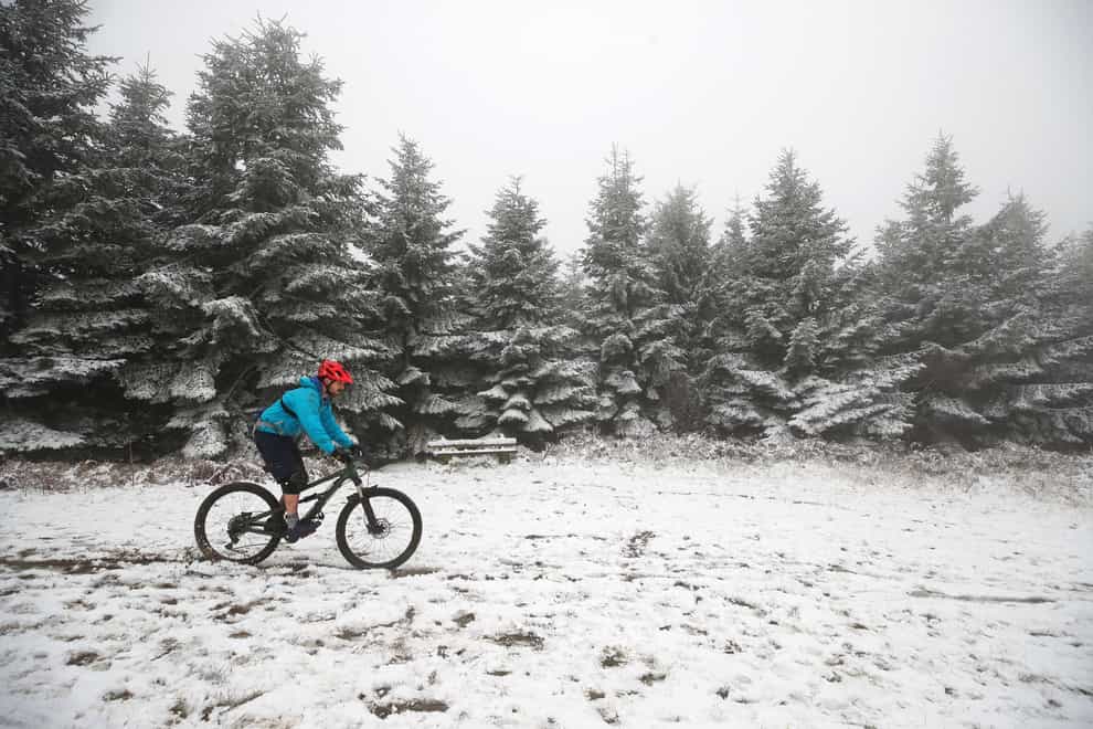 A man cycles through the snow in Mortimer Forest near Ludlow in Shropshire