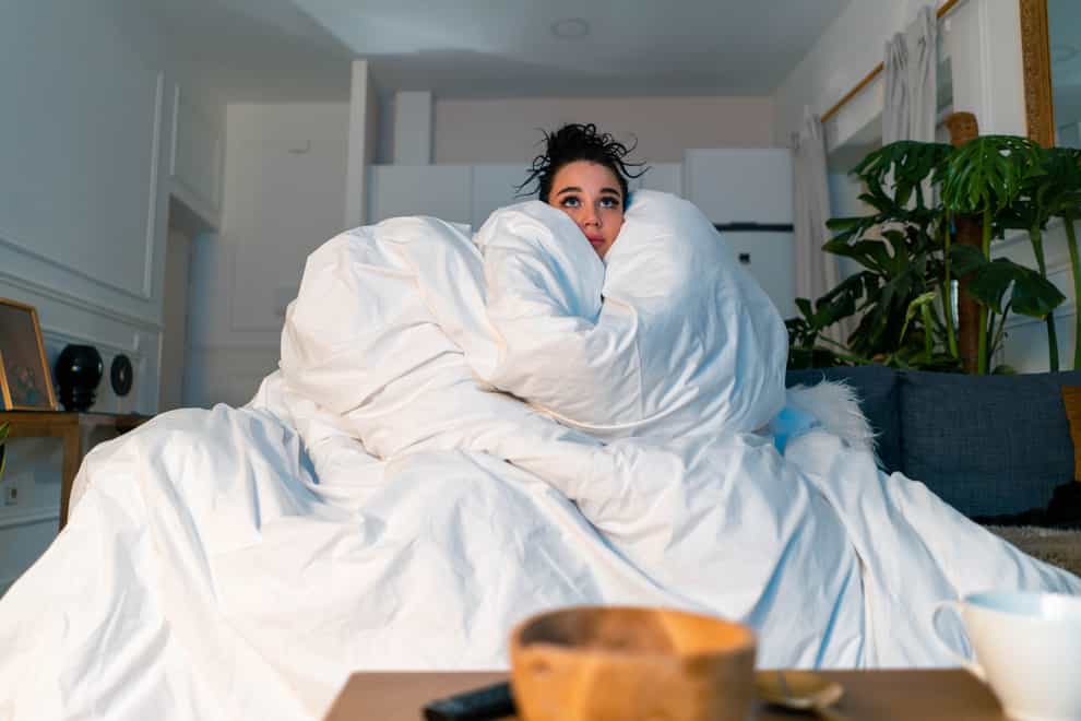 Woman on the sofa wrapped in a duvet