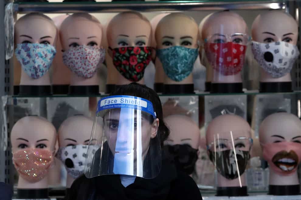 Sales assistant in face shield with face masks