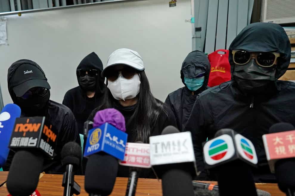 Relatives of a group of jailed Hong Kong activists concealing their identities at a Hong Kong press conference