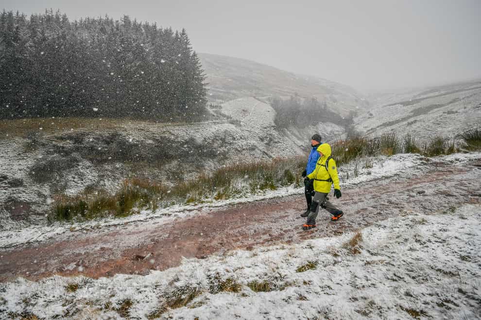 People descend Pen y Fan as snow falls on the Brecon Beacons National Park, Wales,