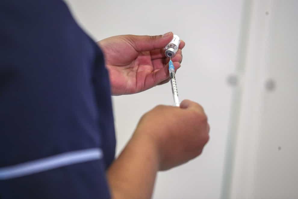 A nurse prepares a vaccine