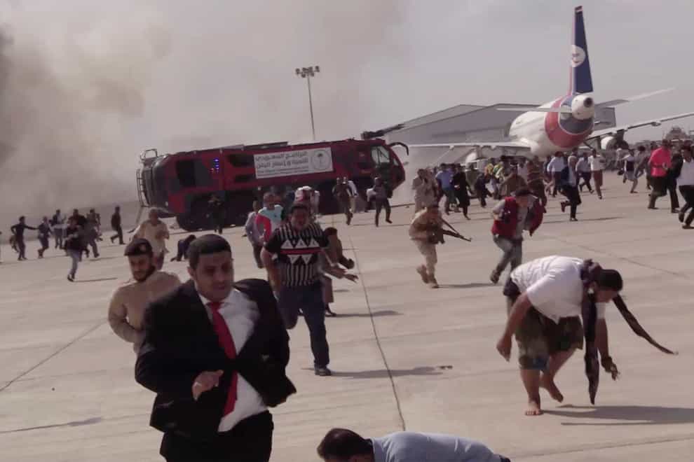 People run after an explosion at the airport in Aden, Yemen