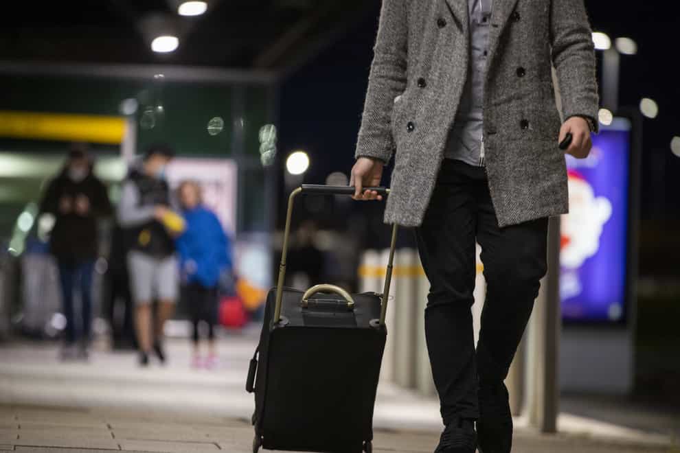 A man pulling a suitcase on wheels