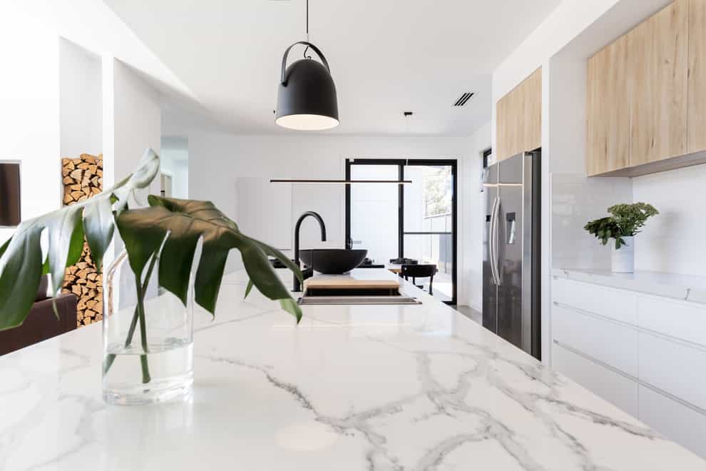 A lovely modern white kitchen with marble worktops and high-end design features