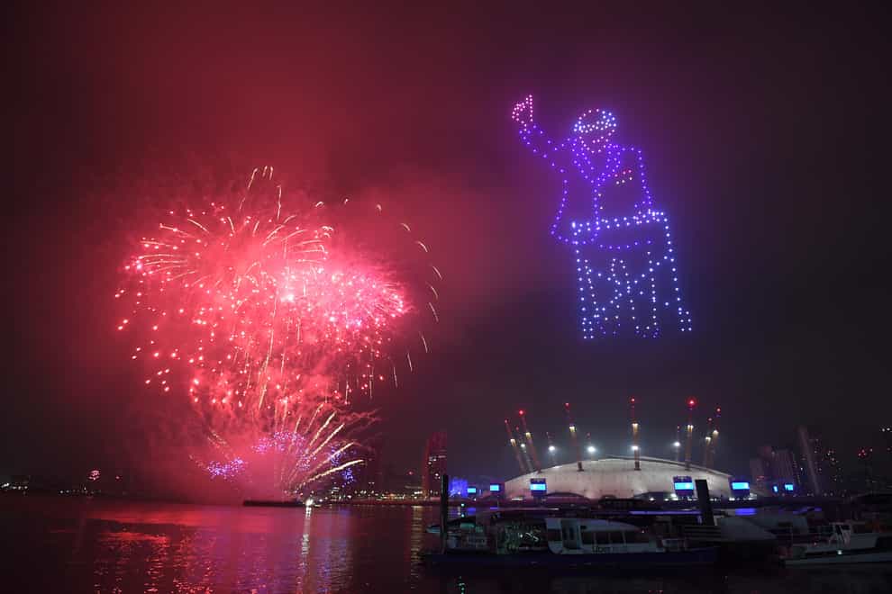 Fireworks erupt behind a drone display of Captain Tom Moore in London's New Year's Eve celebrations