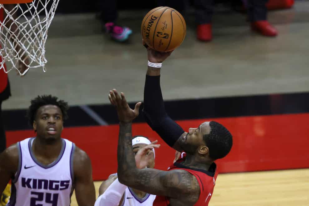 Houston Rockets’ John Wall, right, puts up a basket against the Sacramento Kings