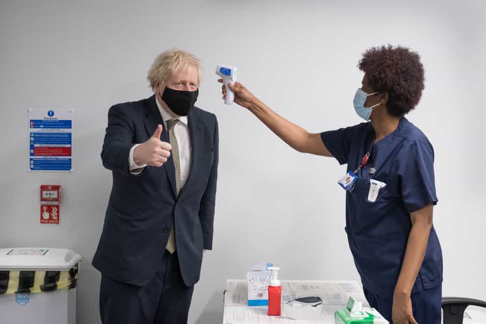 Prime Minister Boris Johnson has his temperature checked during a visit to view the vaccination programme at Chase Farm Hospital