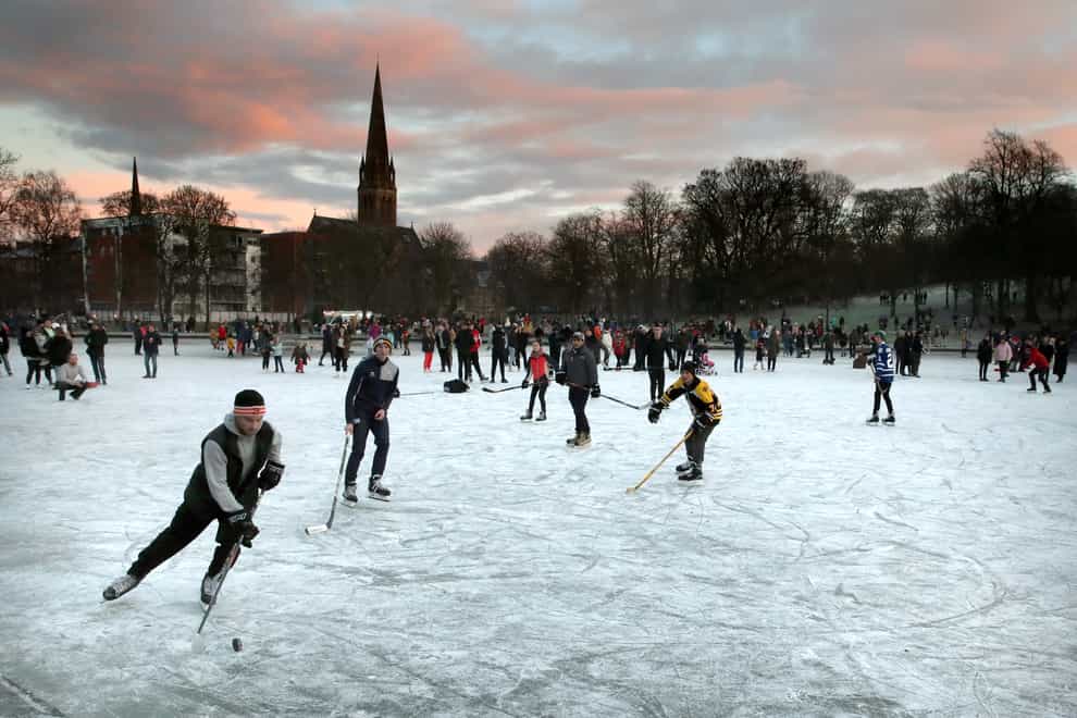 People play ice hockey on a frozen pond in Queen's Park, Glasgow