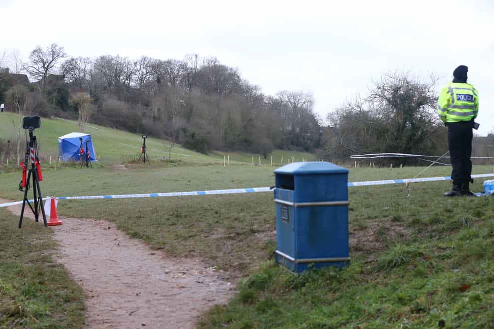 A police officer watches as a forensic tent is set up in Bugs Bottom field in Emmer Green, Reading, where a 13-year-old boy died after being stabbed on Sunday
