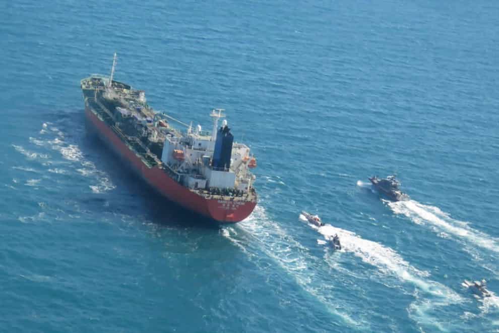 A seized South Korean-flagged tanker is escorted by Iranian Revolutionary Guard boats on the Persian Gulf (Tasnim news agency/AP)
