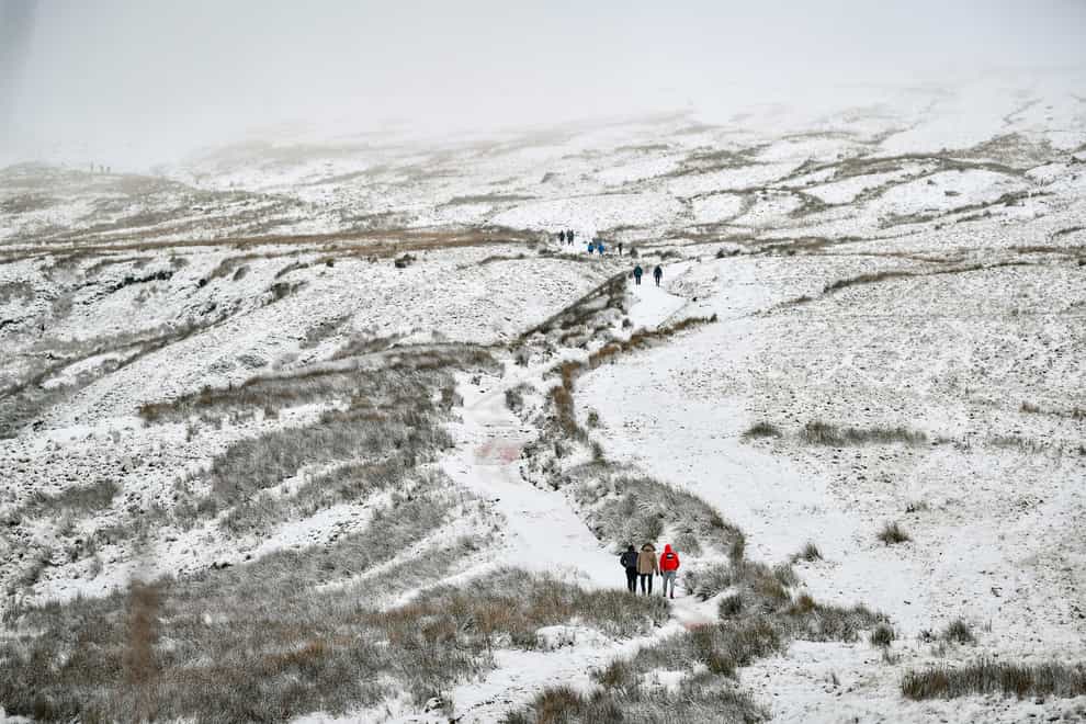 Walkers ascend the path to the top of Pen y Fan, South Wales’ highest mountain, in snowy conditions