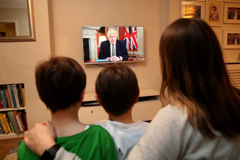 A family in Knutsford, Cheshire, watch Prime Minister Boris Johnson making a televised address