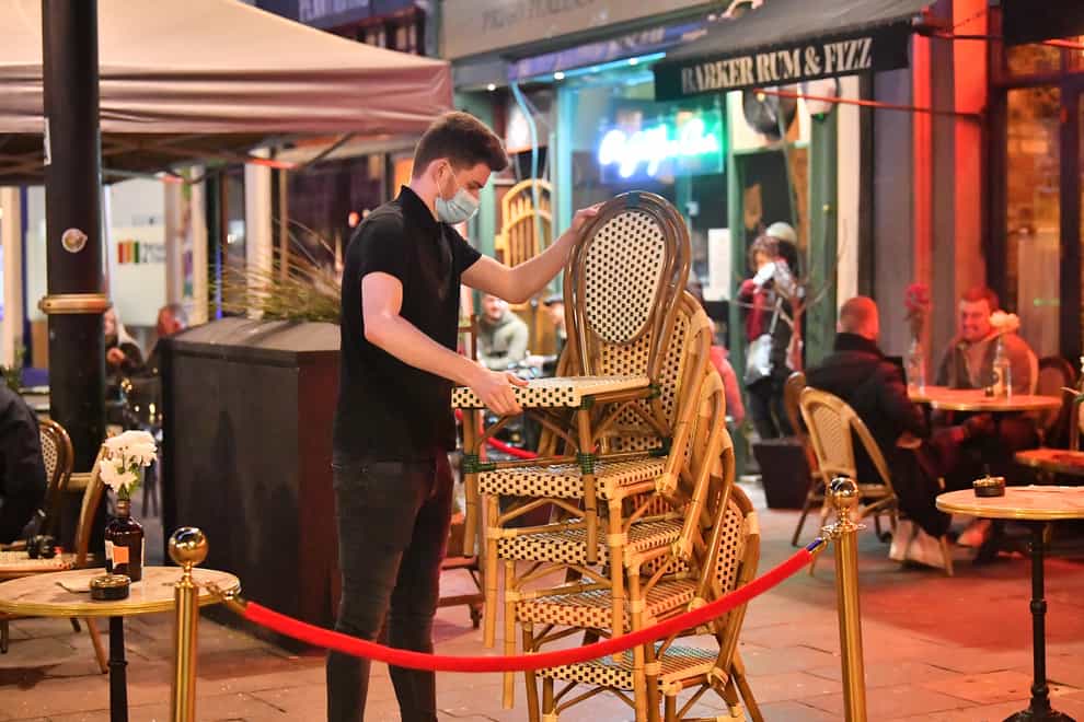 Bar staff pack away chairs and tables in Cardiff