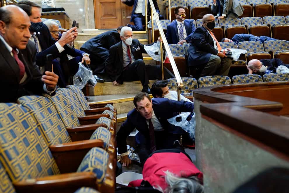 People shelter in the House gallery as protesters try to break into the House Chamber at the US Capitol