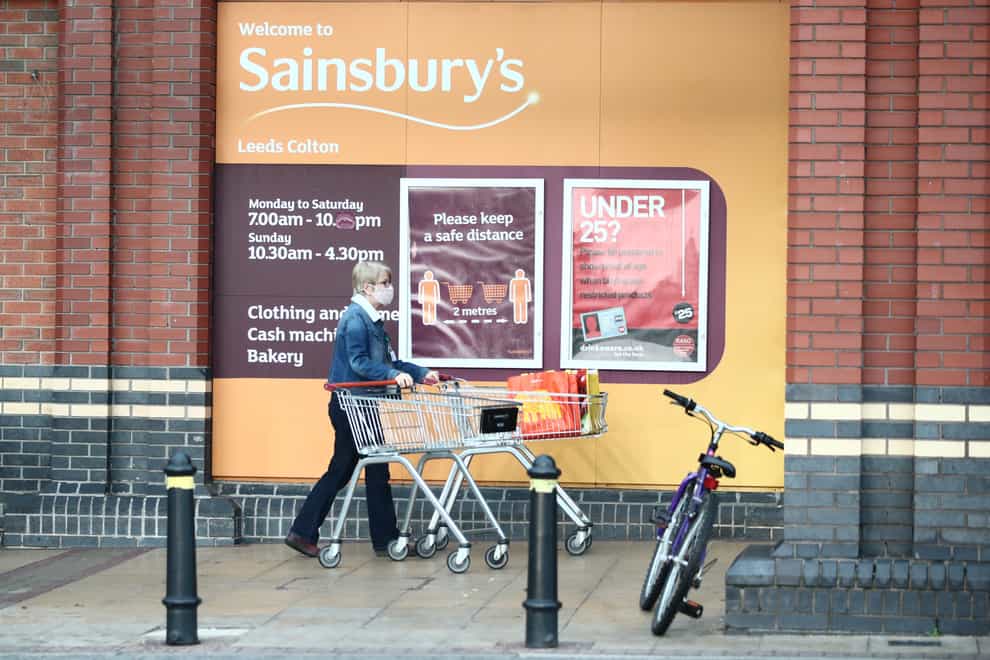A shopper in a mask outside a Sainsbury's store