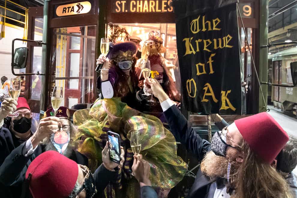 Peggy Scott Laborde and members of the Krewe of Oak toast Carnival as the Phunny Phorty Phellows start their 40th anniversary streetcar ride ushering in Carnival at the Willow Street car barn in New Orleans, (David Grunfeld/The New Orleans Advocate/AP)