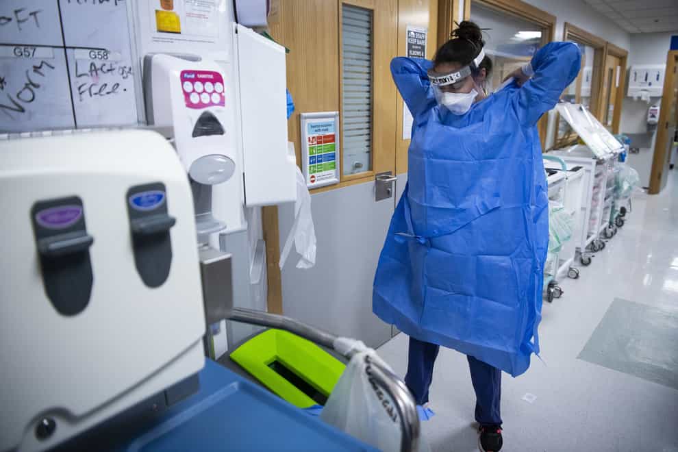 A staff nurse puts on PPE in the corridor of the Acute Dependency Unit at St George’s Hospital in Tooting, south-west London